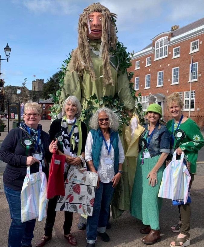 ladies with a giant green lady puppet