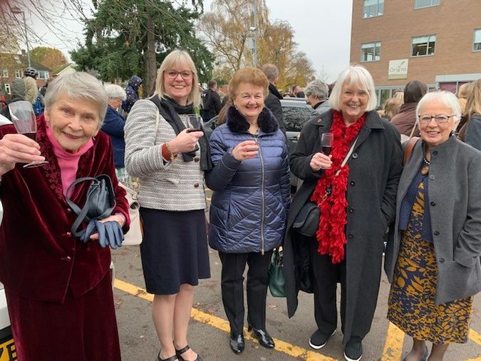 a group of women holding their wine and smiling