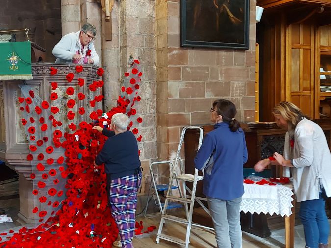 ladies putting up a poppy display
